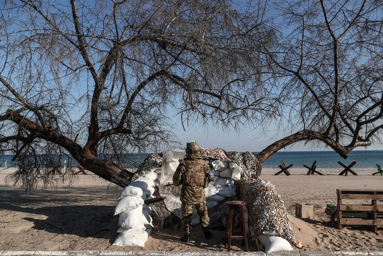 Украинский солдат охраняет баррикады на пляже в Лузановке — районе Одессы
