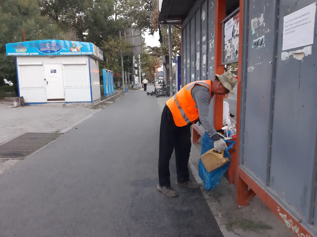 Уборка урны для мусора на остановке на улице Ахунбаева