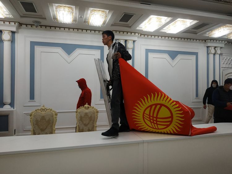 Митингующий с флагом Кыргызстана и бутылкой водки в здании Жогорку Кенеша