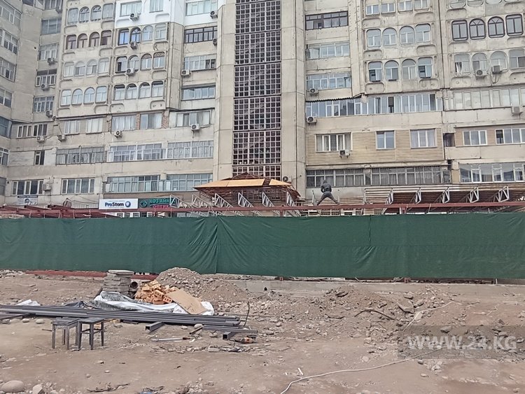 Возле забора многоэтажного дома возводится пристройка