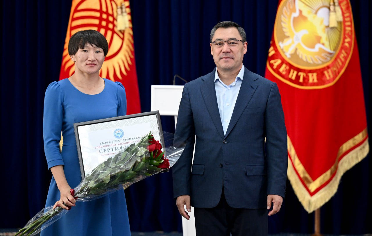 Трижды чемпионка мира по борьбе Айсулуу Тыныбекова во время награждения Садыром Жапаровым