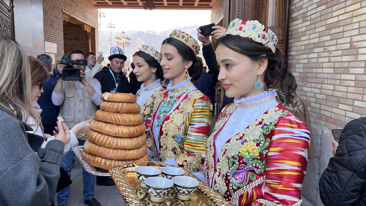 Таджикские девушки встречают с угощением у входа в Худжандскую крепость