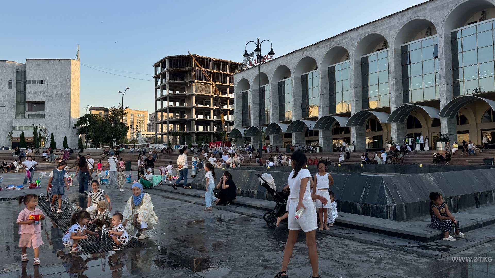 Бишкекчане спасаются от жары возле фонтана на площади Ала-Тоо