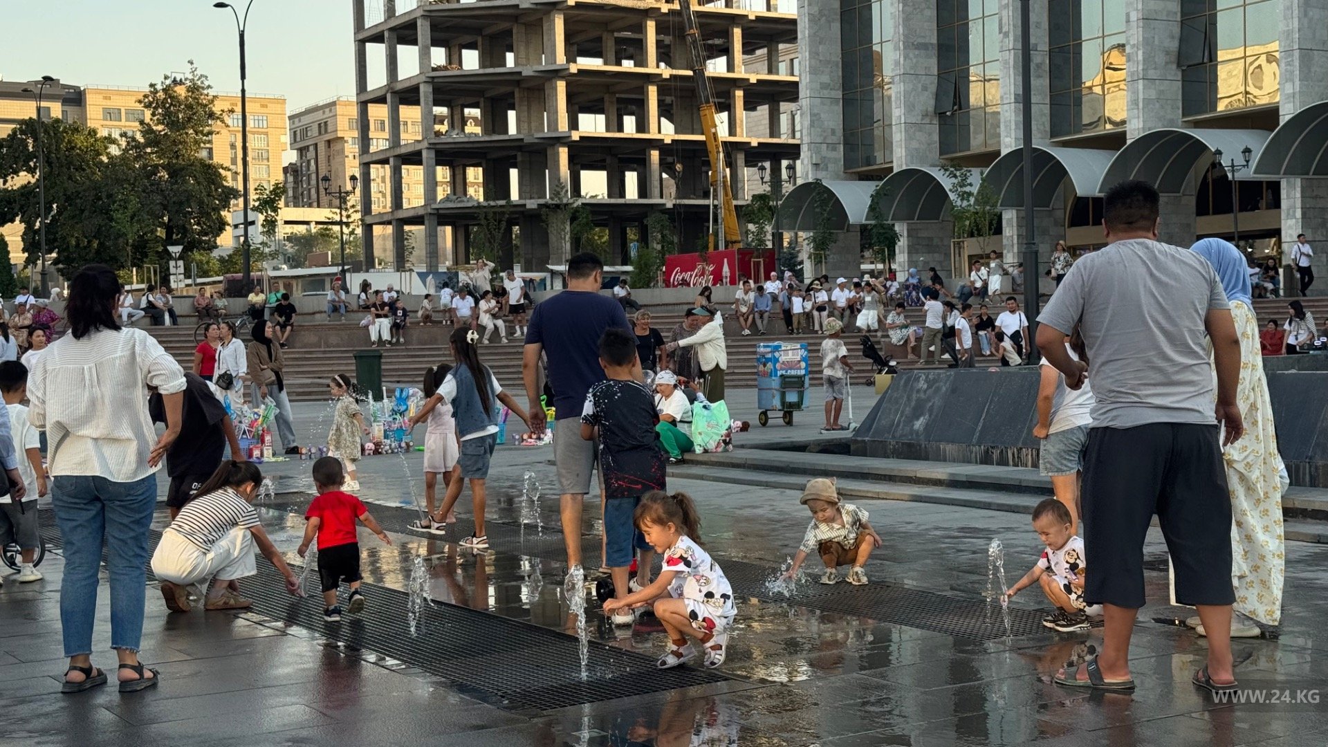 Бишкекчане спасаются от жары возле фонтана на площади Ала-Тоо