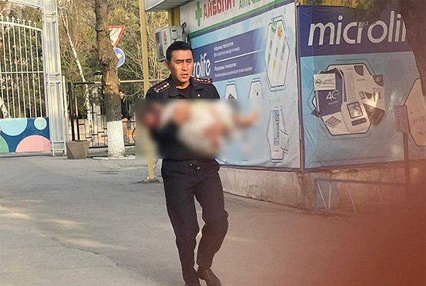 Сотрудник милиции на руках заносит ребенка в больницу