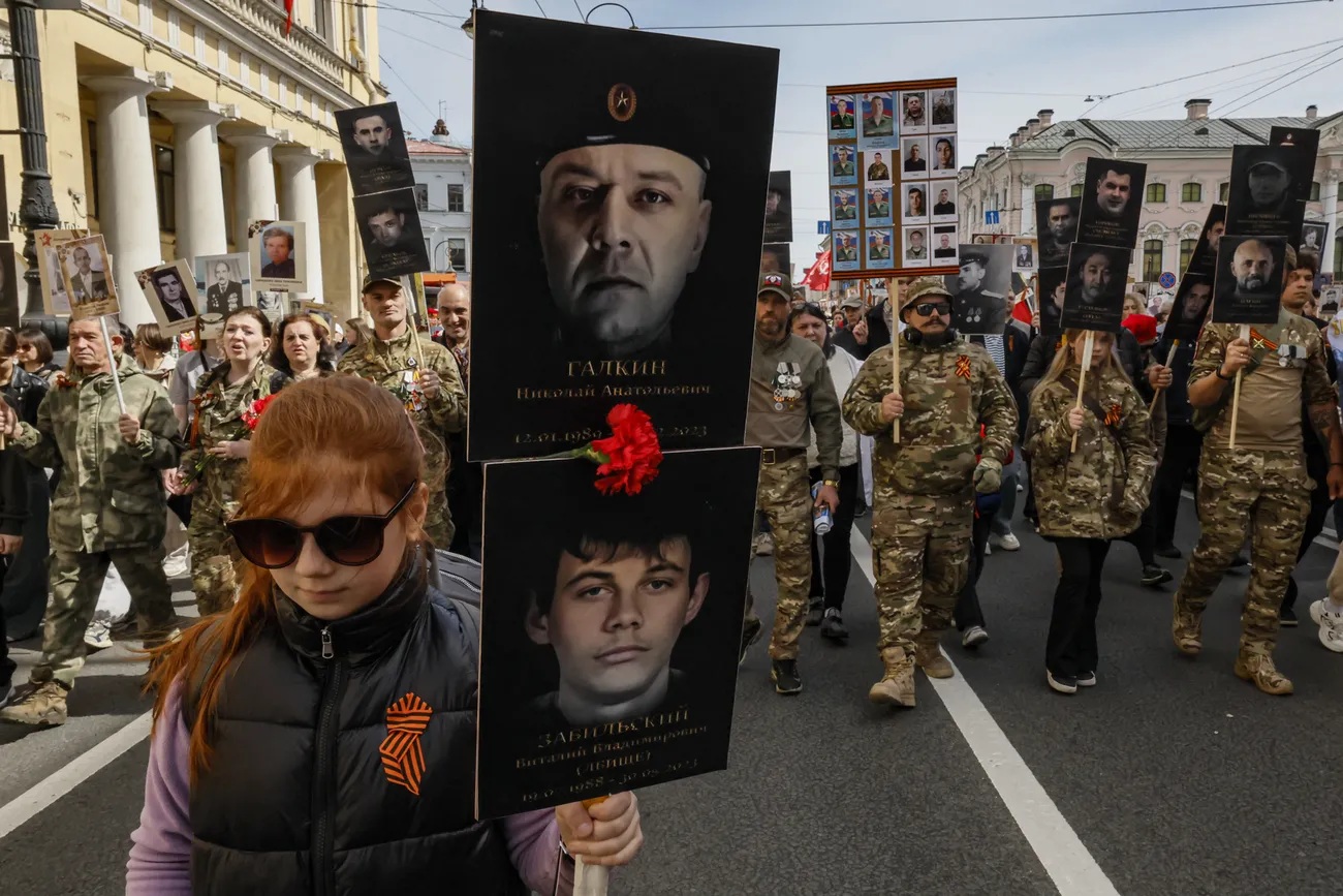 Бойцы ЧВК Вагнера и их близкие несут портреты своих товарищей во время шествия «Бессмертного полка»